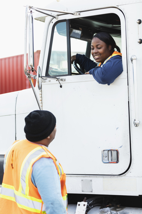 Female truck driver, dock worker conversing Female truck driver at a loading dock